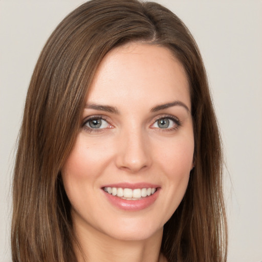 Joyful white young-adult female with long  brown hair and green eyes