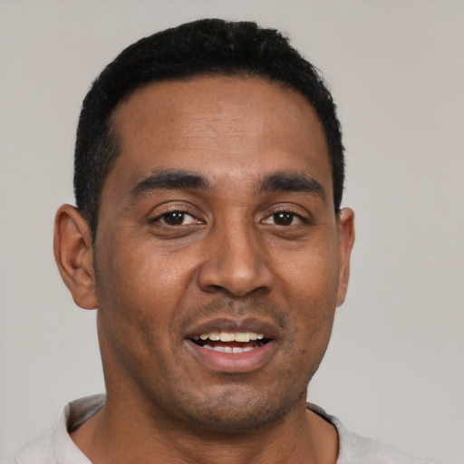 Joyful black young-adult male with short  black hair and brown eyes