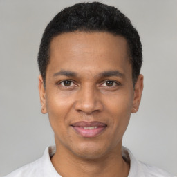 Joyful latino young-adult male with short  black hair and brown eyes