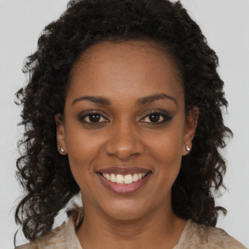 Joyful black young-adult female with medium  brown hair and brown eyes