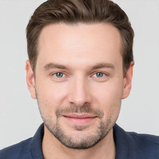 Joyful white young-adult male with short  brown hair and grey eyes