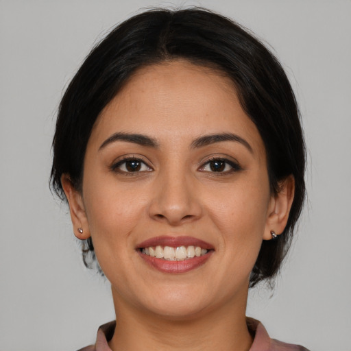 Joyful latino young-adult female with medium  brown hair and brown eyes