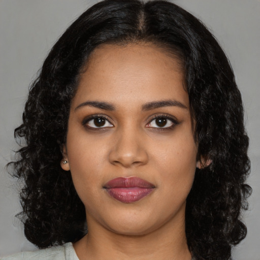 Joyful black young-adult female with long  black hair and brown eyes