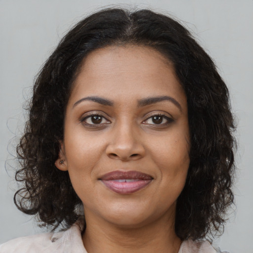 Joyful black young-adult female with medium  brown hair and brown eyes
