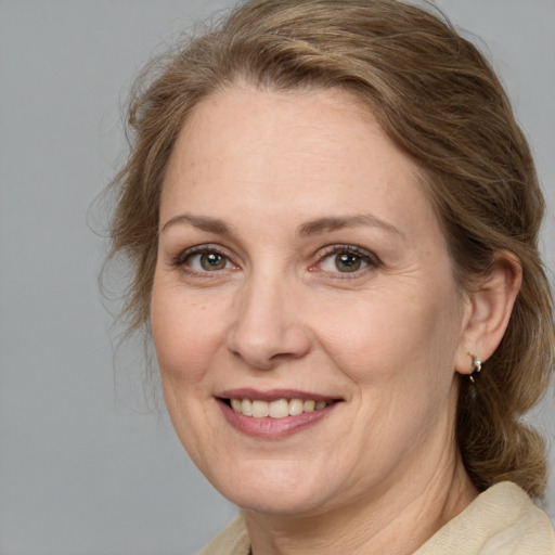 Joyful white adult female with medium  brown hair and green eyes