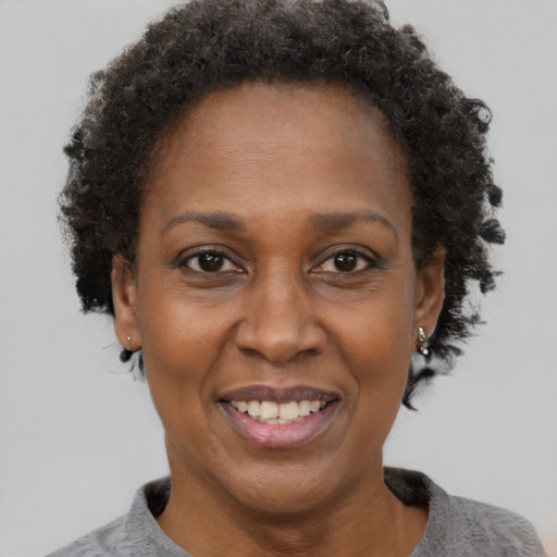 Joyful black adult female with short  brown hair and brown eyes