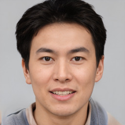 Joyful asian young-adult male with short  brown hair and brown eyes