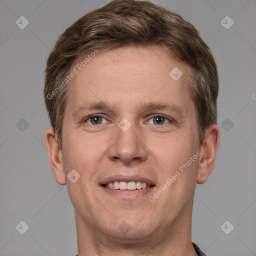 Joyful white young-adult male with short  brown hair and grey eyes