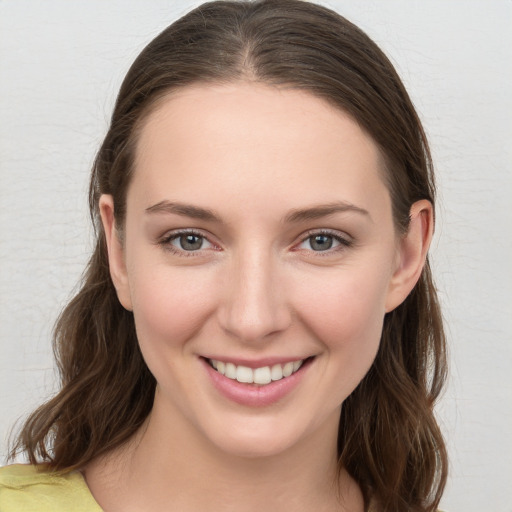 Joyful white young-adult female with long  brown hair and grey eyes