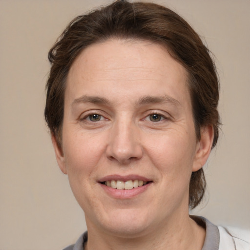 Joyful white adult female with medium  brown hair and grey eyes