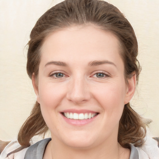 Joyful white young-adult female with medium  brown hair and grey eyes