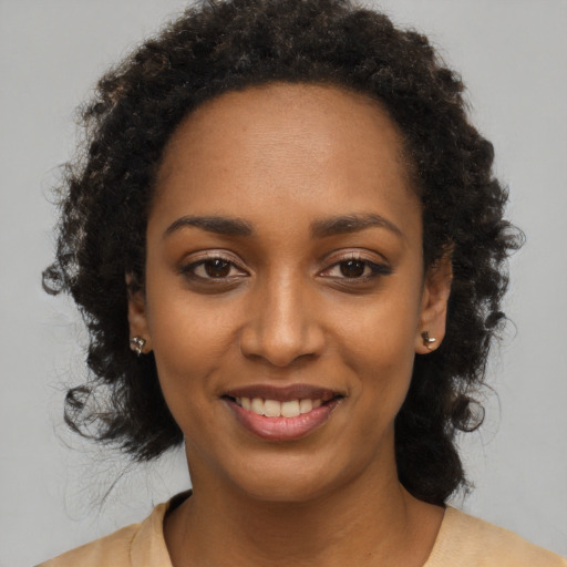 Joyful black young-adult female with long  black hair and brown eyes