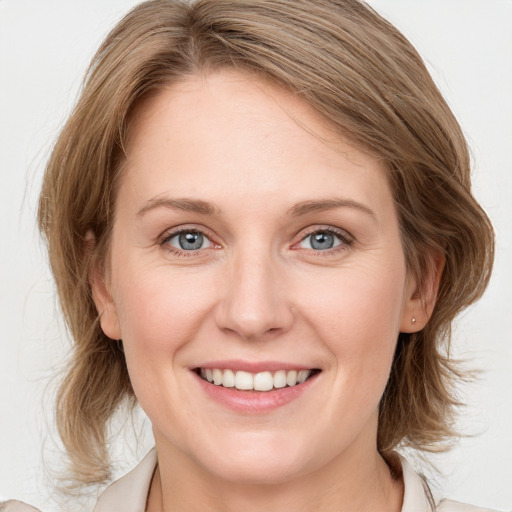 Joyful white young-adult female with medium  brown hair and blue eyes