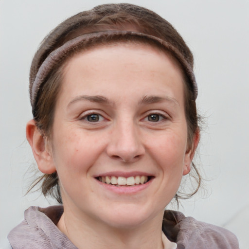 Joyful white young-adult female with medium  brown hair and grey eyes