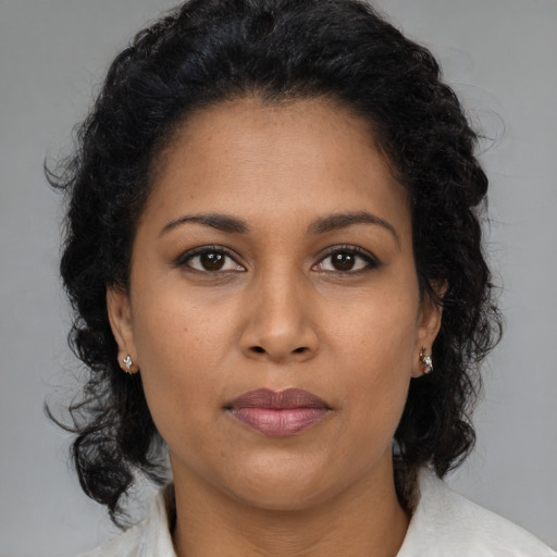 Joyful latino adult female with medium  brown hair and brown eyes