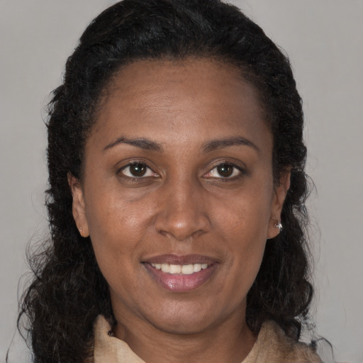 Joyful black adult female with long  brown hair and brown eyes
