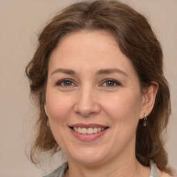 Joyful white adult female with medium  brown hair and grey eyes