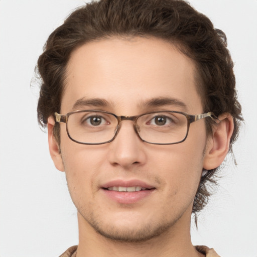 Joyful white young-adult male with short  brown hair and green eyes