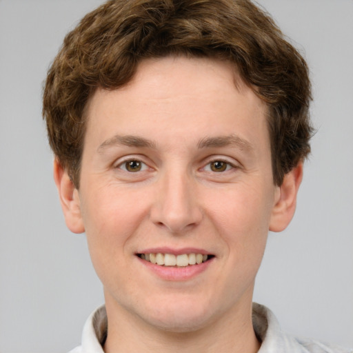 Joyful white young-adult male with short  brown hair and green eyes