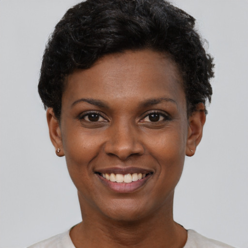Joyful black young-adult female with short  black hair and brown eyes