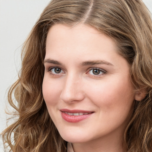 Joyful white young-adult female with long  brown hair and green eyes