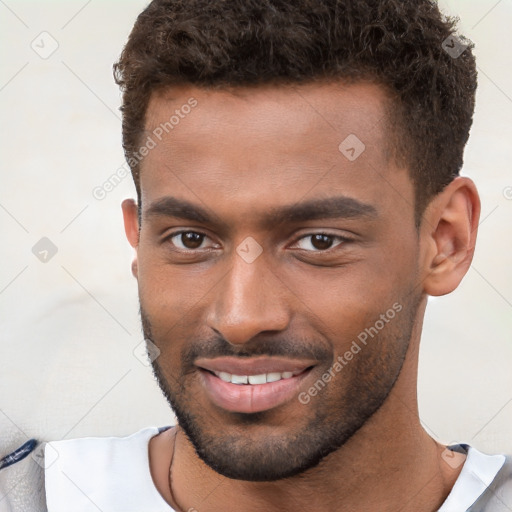 Joyful black young-adult male with short  brown hair and brown eyes