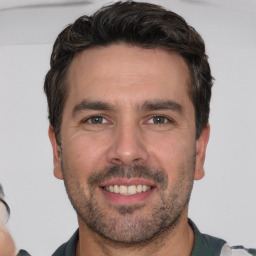 Joyful white adult male with short  brown hair and brown eyes