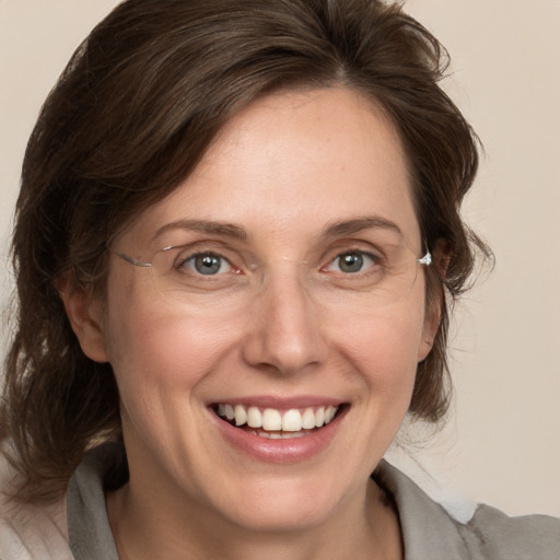 Joyful white adult female with medium  brown hair and grey eyes