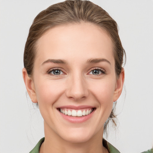 Joyful white young-adult female with medium  brown hair and green eyes