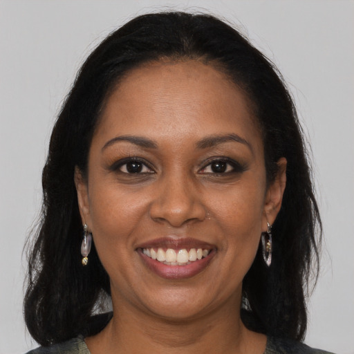 Joyful black young-adult female with long  brown hair and brown eyes