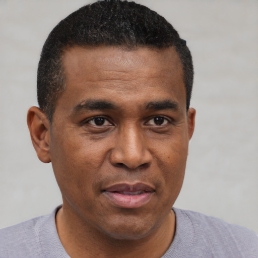 Joyful black young-adult male with short  brown hair and brown eyes