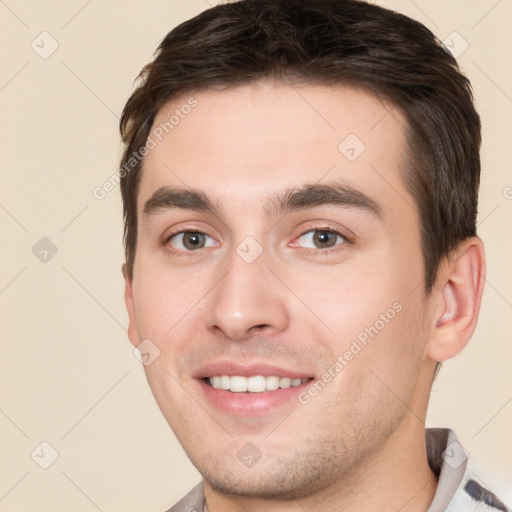 Joyful white young-adult male with short  brown hair and brown eyes