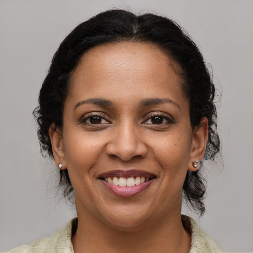 Joyful latino adult female with medium  brown hair and brown eyes