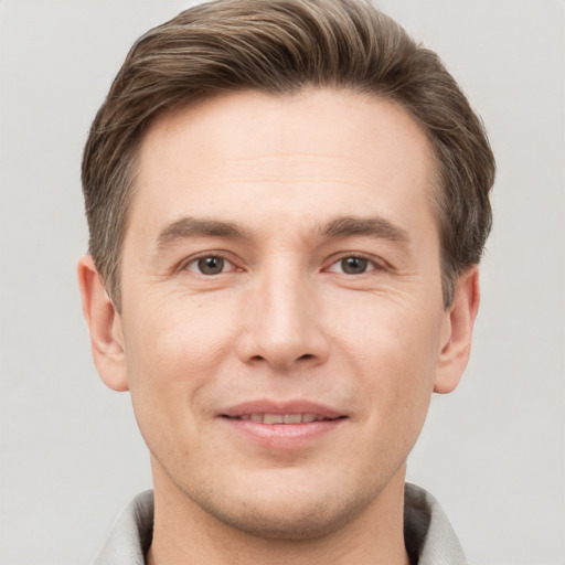 Joyful white adult male with short  brown hair and grey eyes