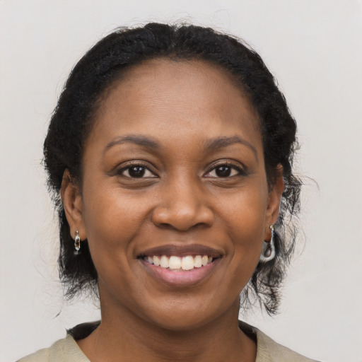 Joyful black young-adult female with medium  brown hair and brown eyes
