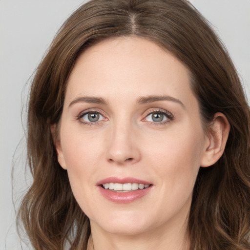 Joyful white young-adult female with long  brown hair and grey eyes