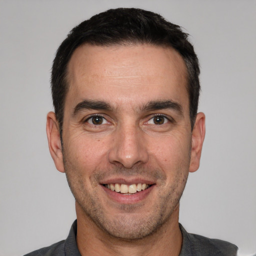 Joyful white adult male with short  brown hair and brown eyes