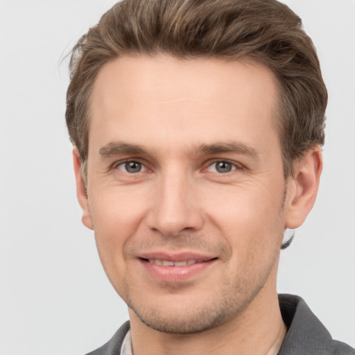 Joyful white young-adult male with short  brown hair and grey eyes