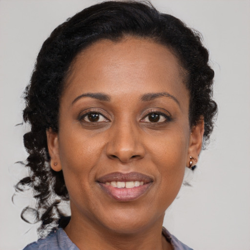 Joyful black adult female with medium  brown hair and brown eyes