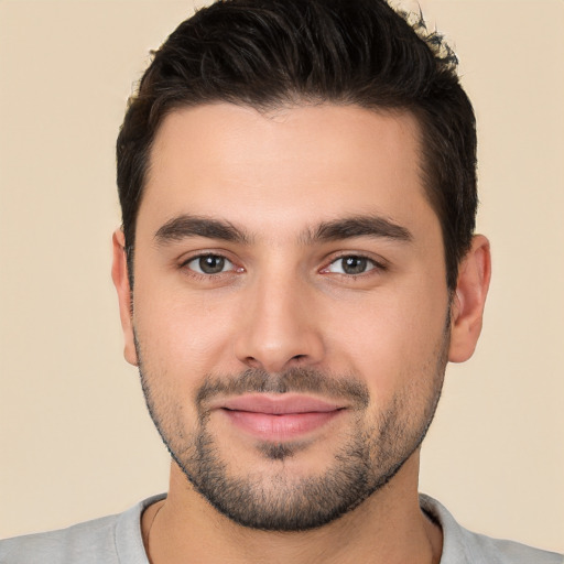 Joyful white young-adult male with short  black hair and brown eyes