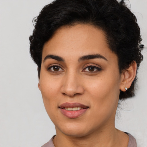 Joyful latino young-adult female with short  black hair and brown eyes