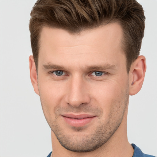 Joyful white young-adult male with short  brown hair and grey eyes