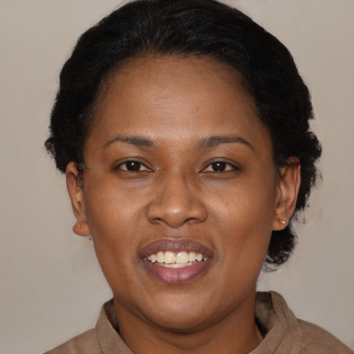 Joyful black adult female with medium  brown hair and brown eyes