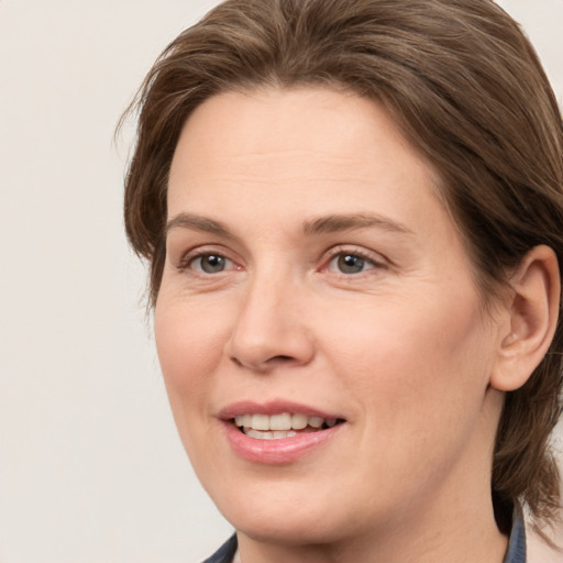 Joyful white adult female with medium  brown hair and grey eyes