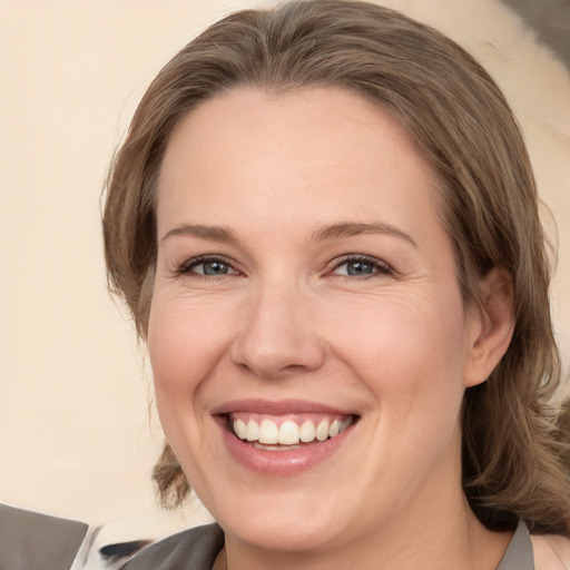 Joyful white adult female with medium  brown hair and grey eyes