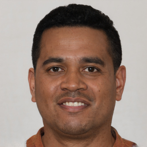 Joyful black young-adult male with short  black hair and brown eyes