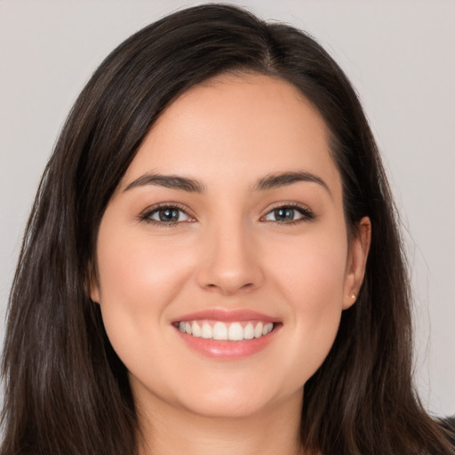 Joyful white young-adult female with long  brown hair and brown eyes