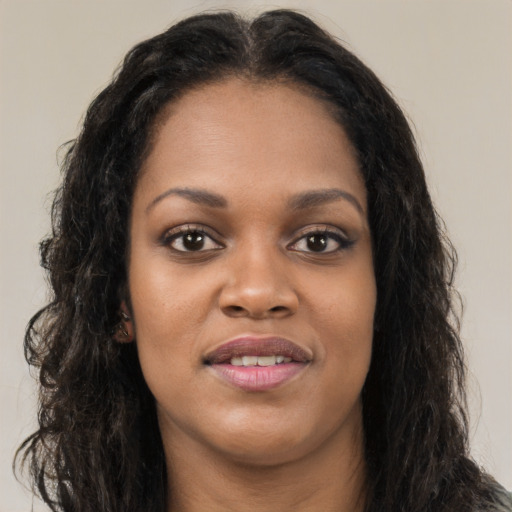 Joyful black young-adult female with long  brown hair and brown eyes