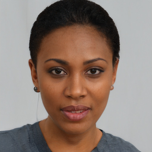 Joyful black young-adult female with short  black hair and brown eyes