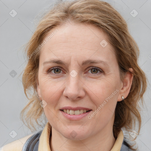 Joyful white adult female with medium  brown hair and blue eyes